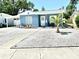 Charming single-story home with blue siding, a well-manicured yard, and a young palm tree at 3318 Boca Ciega N Dr, St Petersburg, FL 33710