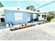 A well-kept single story home with blue siding, a rock yard, and a cute planter by the front door at 3318 Boca Ciega N Dr, St Petersburg, FL 33710