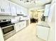 Modern kitchen featuring white cabinets, granite countertops, stainless steel appliances, and tile flooring at 3318 Boca Ciega N Dr, St Petersburg, FL 33710