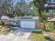 Charming one-story home with manicured lawn, large garage, and beautiful blue exterior at 35 Harbor Oaks Cir, Safety Harbor, FL 34695