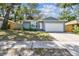 Charming single Gathering home with beautiful light blue exterior and manicured front yard on a sunny day at 35 Harbor Oaks Cir, Safety Harbor, FL 34695