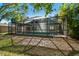 View of the screened-in pool from the backyard and mature trees at 389 Waterford W Cir, Tarpon Springs, FL 34688