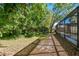Backyard featuring a tree-lined area and screened-in pool at 389 Waterford W Cir, Tarpon Springs, FL 34688
