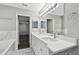 Well-lit bathroom vanity with double sinks, marble countertops, and an open doorway view to the bedroom at 389 Waterford W Cir, Tarpon Springs, FL 34688