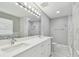 Bright bathroom featuring double sinks, marble countertops, and a spacious shower with elegant tile work at 389 Waterford W Cir, Tarpon Springs, FL 34688