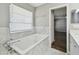 Bright bathroom featuring a soaking tub, white marble surround, and a window that provides natural light at 389 Waterford W Cir, Tarpon Springs, FL 34688