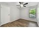 Cozy bedroom featuring a ceiling fan, window with blinds, and modern flooring for a comfortable living space at 389 Waterford W Cir, Tarpon Springs, FL 34688