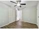 Spacious bedroom featuring a ceiling fan, closet and modern flooring for a comfortable living space at 389 Waterford W Cir, Tarpon Springs, FL 34688
