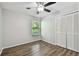 Cozy bedroom with wood floors, a ceiling fan, window, and closet at 389 Waterford W Cir, Tarpon Springs, FL 34688