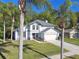 Attractive two-story home surrounded by palm trees, featuring a well-kept lawn and a two-car garage at 389 Waterford W Cir, Tarpon Springs, FL 34688