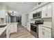 Modern kitchen with stainless steel appliances, granite countertops, and white cabinets at 389 Waterford W Cir, Tarpon Springs, FL 34688