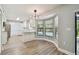 Bright eat-in kitchen featuring white cabinets, modern lighting, and views of the outdoor pool at 389 Waterford W Cir, Tarpon Springs, FL 34688