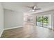 Open-concept living room with hardwood floors, large windows, and access to the pool area at 389 Waterford W Cir, Tarpon Springs, FL 34688