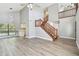 Spacious living area with wood floors, a staircase, and views to the kitchen and upstairs at 389 Waterford W Cir, Tarpon Springs, FL 34688