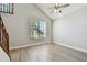 Light-filled living room featuring vaulted ceilings, a ceiling fan, wood floors, and a large window at 389 Waterford W Cir, Tarpon Springs, FL 34688