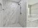 Elegant shower with marble and mosaic tile, and a glimpse of a soaking tub, creating a spa-like ambiance at 389 Waterford W Cir, Tarpon Springs, FL 34688