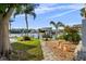 Scenic backyard with lush landscaping, a paved walkway, and a private dock with boat lift access to waterfront at 3918 Versailles Dr, Tampa, FL 33634