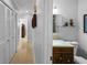 Hallway leading to a full bathroom with tile floors and earth tone finishes at 3918 Versailles Dr, Tampa, FL 33634