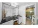 Modern bathroom with double sinks, black granite countertop, and large mirror, leading to the walk-in shower at 3918 Versailles Dr, Tampa, FL 33634