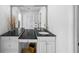 Bright bathroom featuring dual sinks with black granite countertop and a large mirror at 3918 Versailles Dr, Tampa, FL 33634