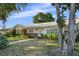 Charming single-story home showcasing a well-kept lawn, mature trees, and a classic brick-accented facade at 3918 Versailles Dr, Tampa, FL 33634