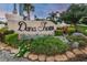 Community sign with lush landscaping and tropical plants, welcoming residents to Dana Shores at 3918 Versailles Dr, Tampa, FL 33634