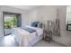Bright bedroom showcasing white walls, a comfortable bed, a side table, and sliding glass door at 4290 Carlos Ct, Hernando Beach, FL 34607