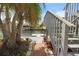 A brick walkway leads to the waterfront dock through a yard featuring lush landscaping and a palm tree at 4290 Carlos Ct, Hernando Beach, FL 34607
