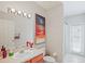 Bright bathroom featuring a single vanity, art, and a shower with glass door at 4608 Kilcoyne Ct, Lutz, FL 33558