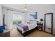 Comfortable bedroom featuring a large window, bedside tables, and a full-length mirror at 4608 Kilcoyne Ct, Lutz, FL 33558