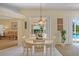 Bright dining area featuring a round table, white chairs, and views of the outdoor patio and pool at 4608 Kilcoyne Ct, Lutz, FL 33558