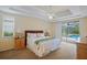 Bright main bedroom boasts a tray ceiling, ceiling fan, and sliding glass doors to the screened-in lanai and pool at 4608 Kilcoyne Ct, Lutz, FL 33558