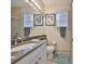 Well-lit bathroom features a large mirror and neutral tile at 4961 Marble Springs Cir, Wimauma, FL 33598