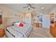Bedroom with a neutral color scheme, ceiling fan and view into the en-suite bathroom at 4961 Marble Springs Cir, Wimauma, FL 33598