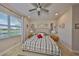 Bedroom with a ceiling fan, large window, and a bed with patterned bedding at 4961 Marble Springs Cir, Wimauma, FL 33598