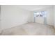 Bright bedroom with neutral walls, natural light, and window with floral curtains at 5660 80Th N St # D207, St Petersburg, FL 33709