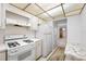 Well-lit kitchen with white appliances, laminate counters, and view to a living space at 5660 80Th N St # D207, St Petersburg, FL 33709