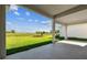 Spacious covered back patio with view of the backyard and a serene pond beyond at 5979 Hidden Branch Dr, Apollo Beach, FL 33572