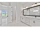 Bathroom featuring double sinks, white marble floors, and a doorway that leads into the bedroom at 5979 Hidden Branch Dr, Apollo Beach, FL 33572