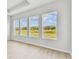 Bright bedroom featuring wood-look floors and several windows with views of green space at 5979 Hidden Branch Dr, Apollo Beach, FL 33572
