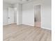 Spacious bedroom with wood-look floors leading to an open doorway and entry to an additional room at 5979 Hidden Branch Dr, Apollo Beach, FL 33572