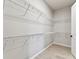 Large walk-in closet with white wire shelving for optimal storage and organization solutions at 5979 Hidden Branch Dr, Apollo Beach, FL 33572