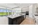 Stylish kitchen featuring a spacious island, stainless steel appliances, and backyard view at 5979 Hidden Branch Dr, Apollo Beach, FL 33572