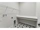 Laundry room with custom shelving and unique black and white star-patterned flooring at 5979 Hidden Branch Dr, Apollo Beach, FL 33572