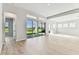 Bright living room featuring sleek flooring, slider doors to outside, and large windows showcasing the outdoor space at 5979 Hidden Branch Dr, Apollo Beach, FL 33572