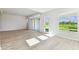 Bright living room featuring sleek flooring, slider doors to outside, and large windows showcasing the outdoor space at 5979 Hidden Branch Dr, Apollo Beach, FL 33572