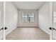 Clean, bright room with hard floors and two windows, showcasing modern minimalist design and simple elegance at 5979 Hidden Branch Dr, Apollo Beach, FL 33572