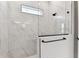 Modern glass enclosed shower featuring marble tile, a rain shower head and convenient grab bar at 5979 Hidden Branch Dr, Apollo Beach, FL 33572
