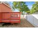 Spacious backyard with a wooden deck and well-maintained white fence at 6414 N Central Ave, Tampa, FL 33604