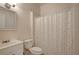 Bathroom with a mirror and sink, toilet, and shower with patterned shower curtain at 6414 N Central Ave, Tampa, FL 33604